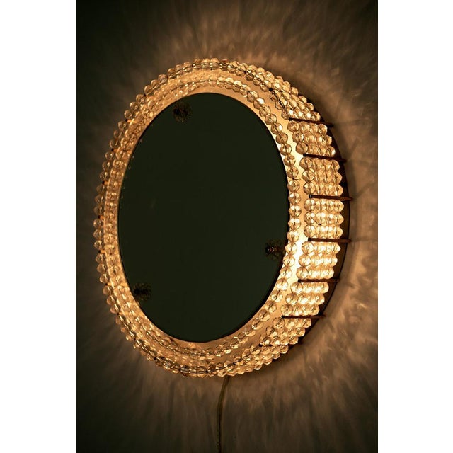 Contessa Leuchten round mirror with light. The mirror is made from metal and decorated with acrylic beads. In a good...
