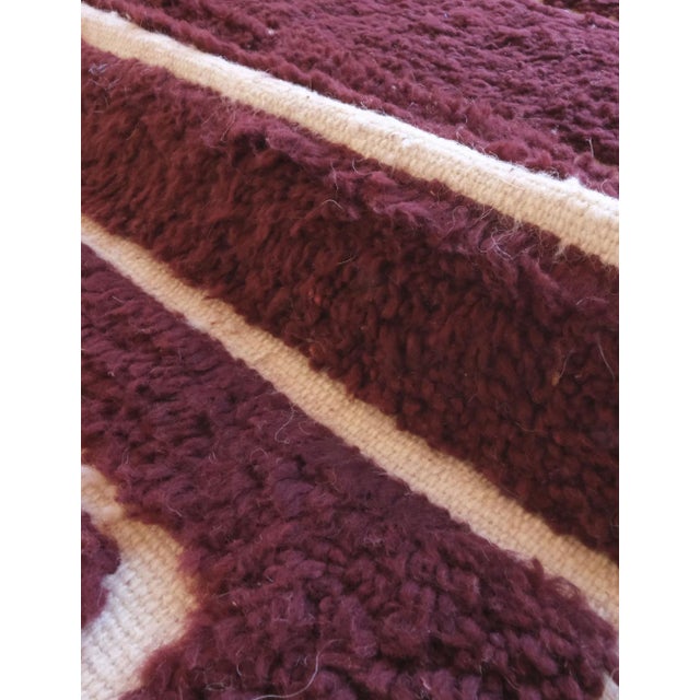 This Burgundy Textured Moroccan Wool Rug, measuring 9.3 by 6.8 feet, brings a warm and inviting touch to any room. Its...
