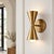 A sculptural pair of handcrafted brass wall sconces featuring a distinctive double-cone silhouette. Each fixture combines...