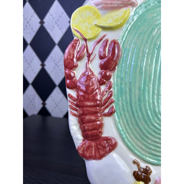 Signed sculptural ceramic wall platter featuring an exuberant arrangement of marine life and citrus in dimensional relief....