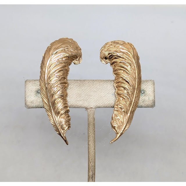 Late 1950s or early 1960s goldtone textured feather up the ear clip earrings. Marked "NAPIER PAT. PEND." on the clips and...
