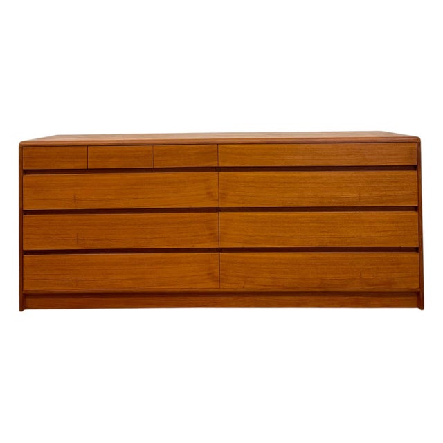 Crafted with rich teak wood showcasing a warm, continuous natural grain, this mid-century modern lowboy dresser features a...