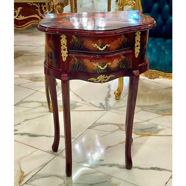 This elegant French style accent table features a rich mahogany-toned finish enhanced by hand-painted decorative artwork...