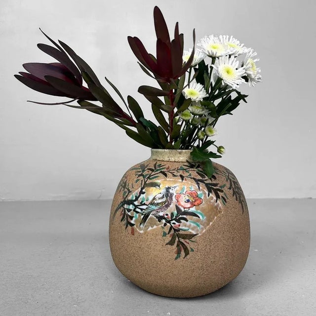 A remarkable Japanese vase with a harmonious, rounded form and a gently flaring neck. The piece is crafted from speckled,...