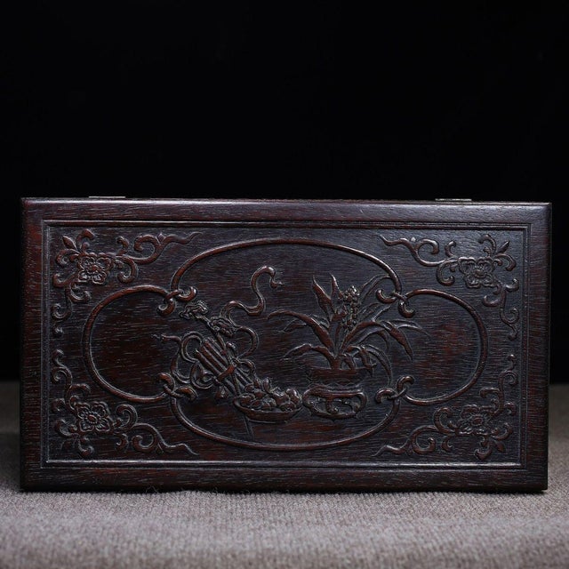 A beautifully crafted Chinese hardwood box, likely made of Zitan wood, featuring deep relief carvings throughout. The lid...