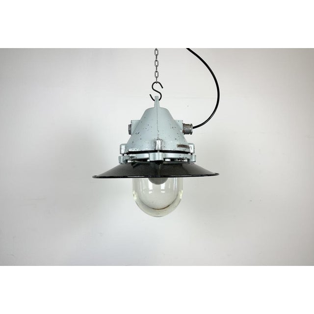 Grey industrial lamp with massive protective glass bulb made by Elektrosvit in former Czechoslovakia during the 1970s.It...