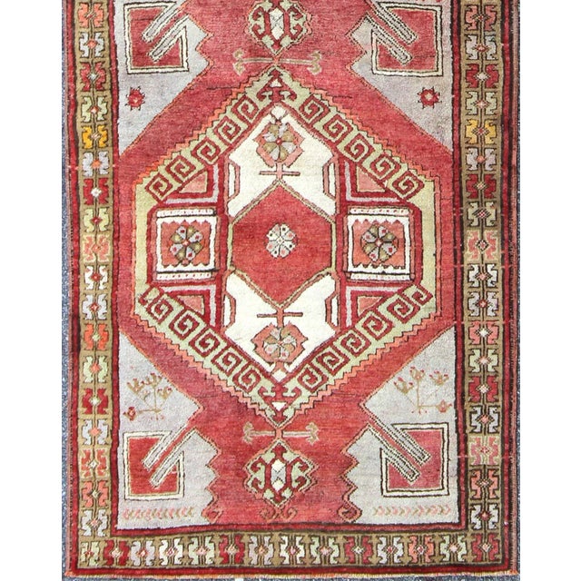 This Turkish Oushak Keivan Woven Arts / runner, from the mid-20th century Oushak, features a central medallion design as...