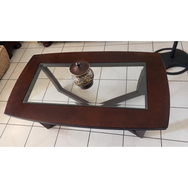 Elegant traditional living room table set featuring a rich dark brown wood finish with inset glass tops and decorative...