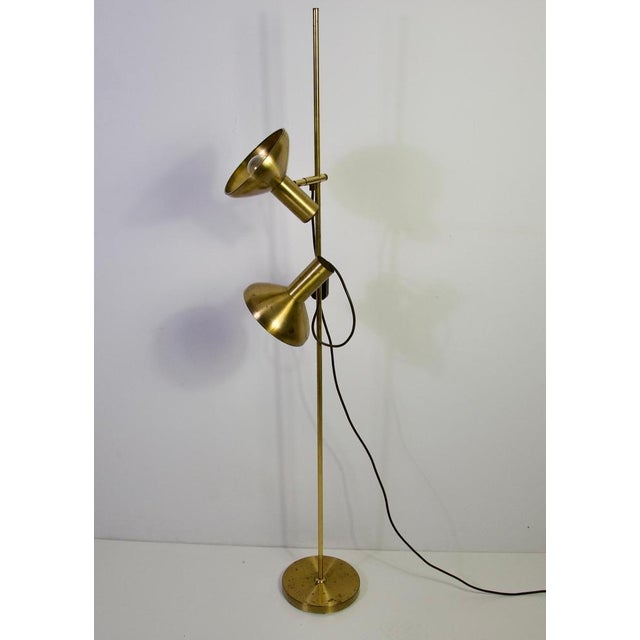 Brass adjustable floor lamp, germany, 1970s. This elegant vintage floor lamp features a slim vertical brass stem on a...
