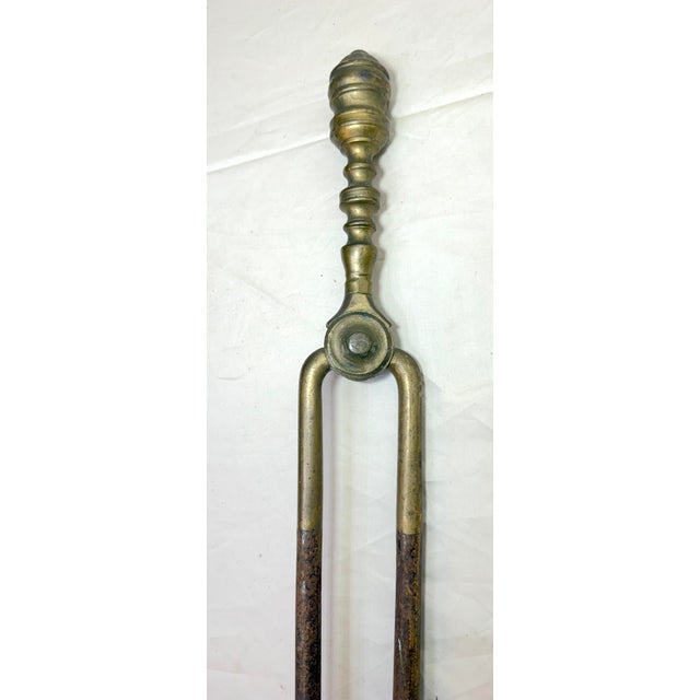 Up for sale is a nice pair of rare antique 18th century wrought iron and brass English fireplace tongs. The arms are...