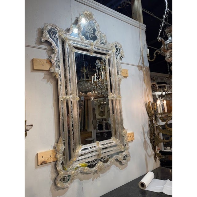 Vintage Italian Murano glass etched mirror. A vintage Italian Murano glass etched mirror sits squarely in the long...
