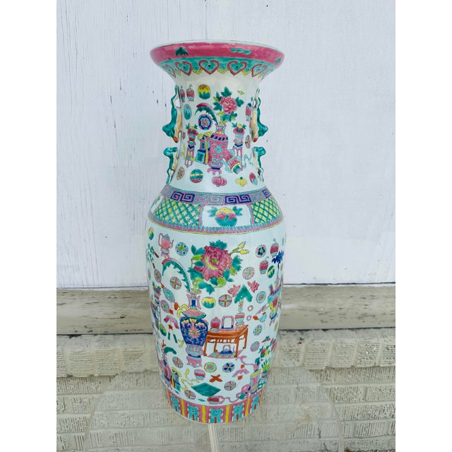 This is a large Chinese porcelain floor vase, richly decorated in the Famille Rose palette—a style known for its soft,...