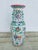 This is a large Chinese porcelain floor vase, richly decorated in the Famille Rose palette—a style known for its soft,...