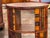 Cylindrical two tier book table, the drum faced with tooled leather book spines in shades of red, tan, and brown with gilt...