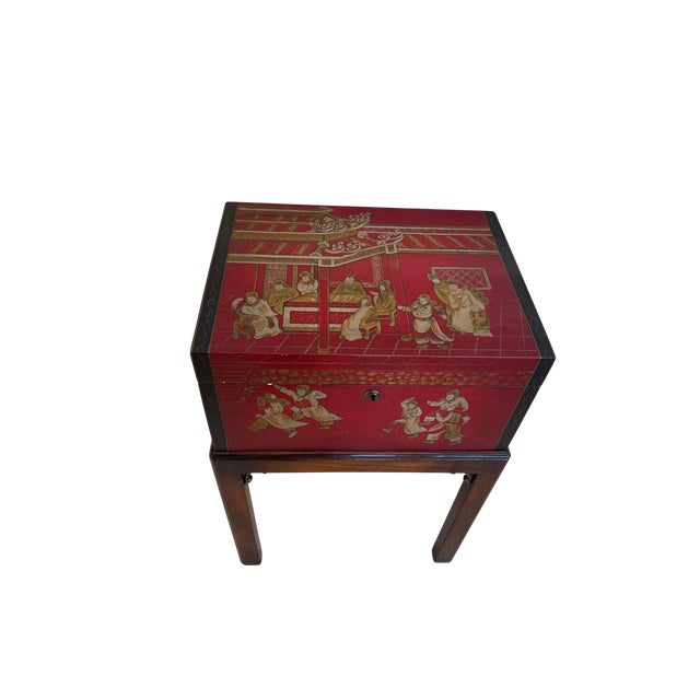 Elegant vintage chinoiserie accent table featuring a richly lacquered red storage chest raised on a warm-toned wood stand....