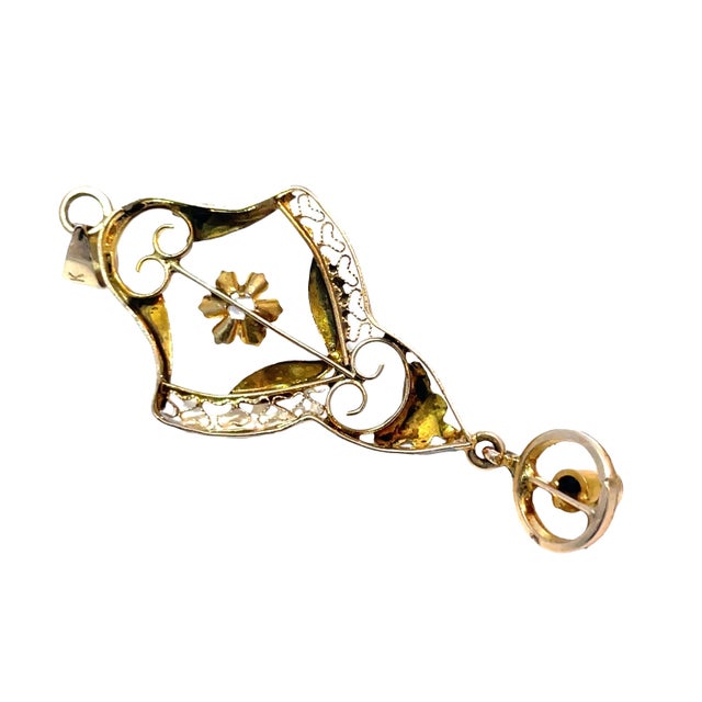 A beautifully preserved pendant, crafted in solid 14k yellow gold and designed with exquisite openwork floral detailing....