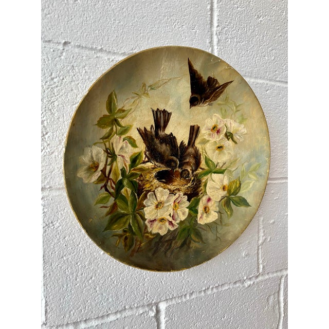 A beautifully hand-painted 19th century papier mâché charger, featuring a charming naturalist scene of birds tending a...