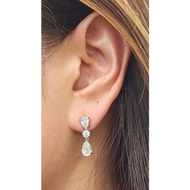 These elegant drop earrings are a stunning addition to any fine jewelry collection. Featuring 4 exquisite pear-cut...