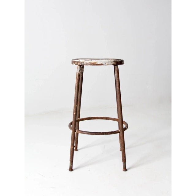 This classic vintage industrial workshop stool showcases authentic character and a timeworn look. The metal counter-height...