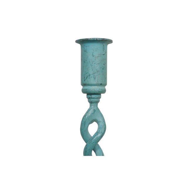 A pair of verdigris candlestick holders. Simple capitals are supported with open barley twist columns, finished with round...