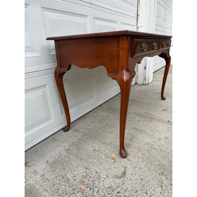 We have an absolutely beautiful vintage Queen Anne style console table for sale. Featuring a rich cherry toned wood...