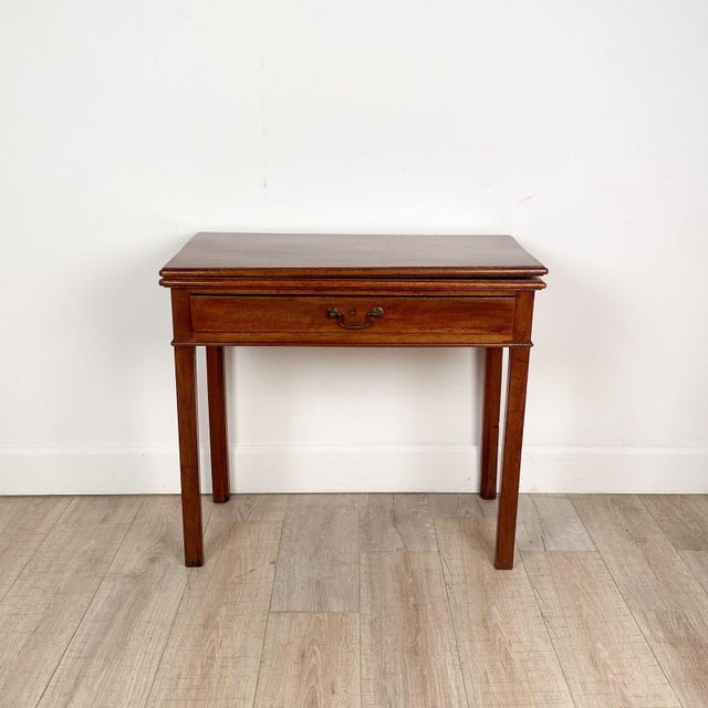 An early 19th-century English mahogany tea table with one drawer, circa 1800. Listed measurements are when closed; when...