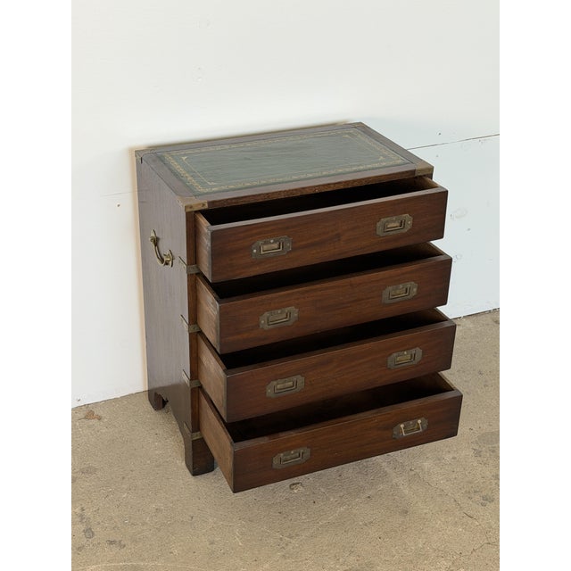 English campaign chest of drawers in mahogany with brass mounts and a tooled leather top, 1930s. It is built in the...