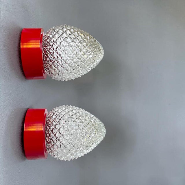A striking set of three vintage (new) wall sconces, combining red plastgic with highly textured clear glass. The contrast...