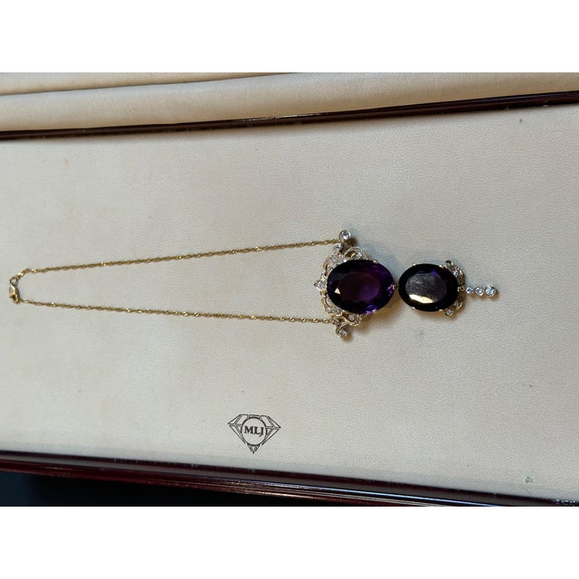 This spectacular pendant necklace/pin consists of two large perfect pear-shaped amethysts, totaling approximately 70...