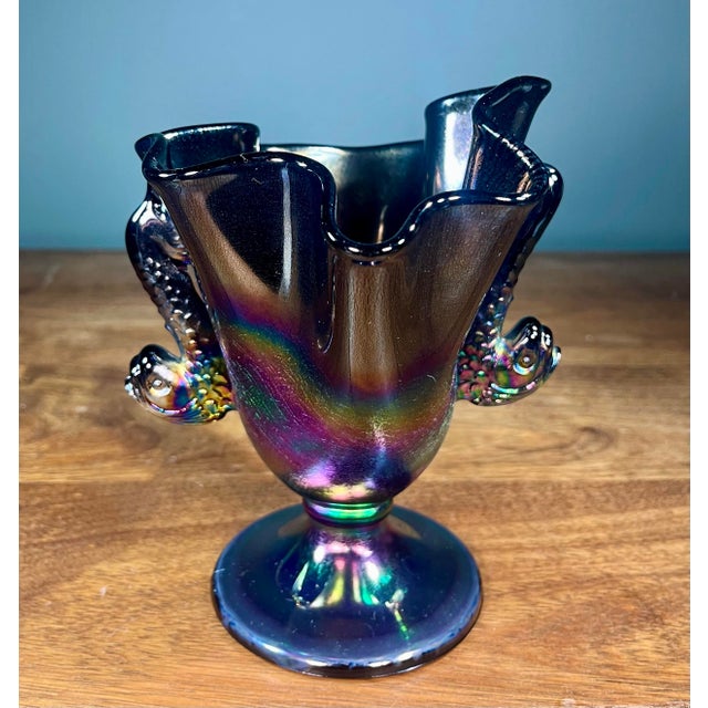 Black amethyst ruffled pedestal glass vase with an iridescent finish and twin dolphin handles.
