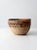 A beautifully woven vintage tribal basket featuring an intricate geometric pattern in soft red, green, and black tones....