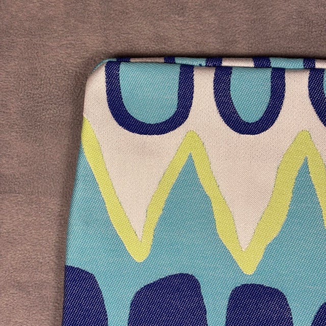 Handmade pillow cover features a vibrant, multi-colored chevron and wavy pattern in shades of blue, turquoise, and lime...