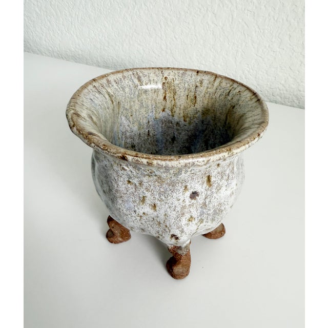 Funky mid-century studio pottery planter with four organic-shaped feet. Red clay body with off-white and brown glaze....
