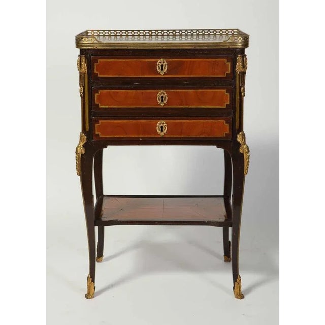 A fine french amaranth and tulipwood gilt bronze mounted table a' ecrire with a " bre'che d'alpe" marble top whitin a...