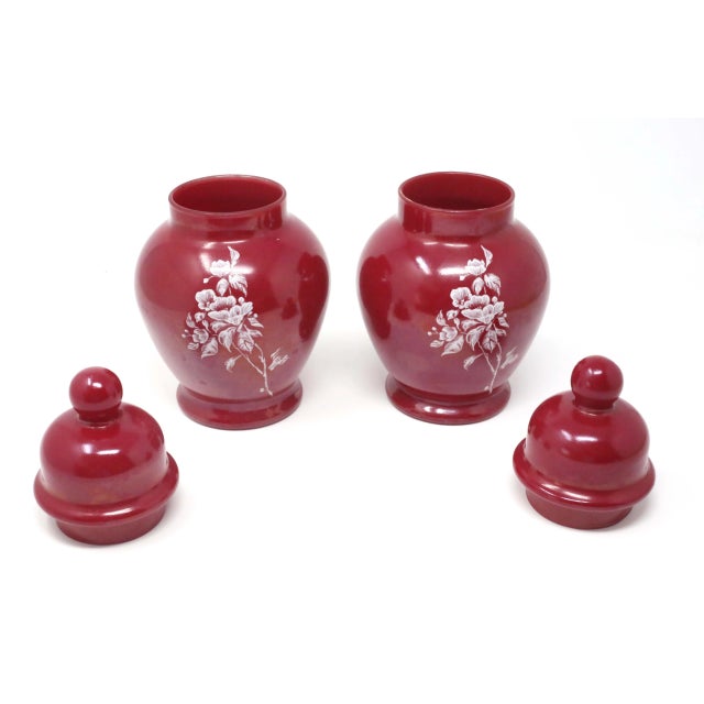 A pair of cinnamon colored glass ginger jars, with white floral design. Good vintage condition; no chips or cracks.