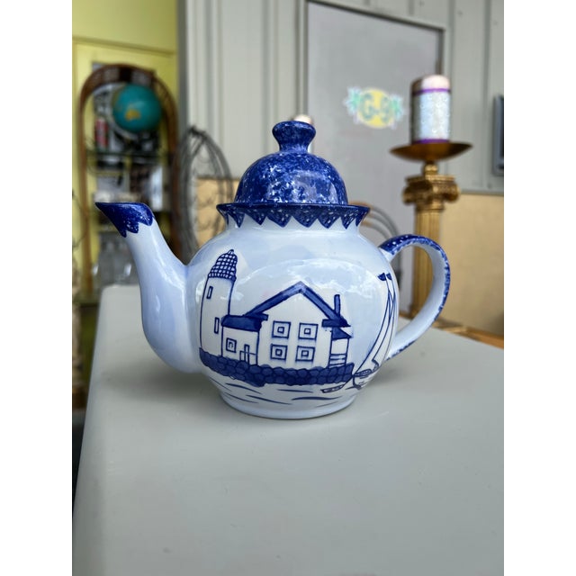 Vintage blue and white ceramic teapot with a nautical theme. It features a distinctive blue and white color scheme with a...