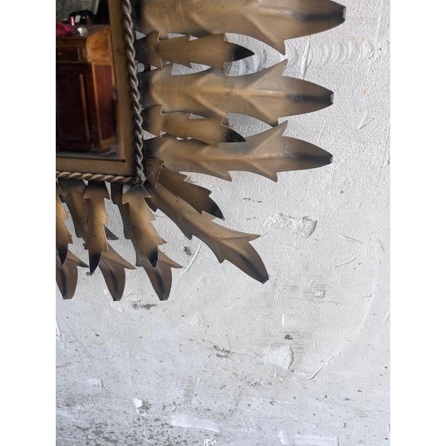 An elegant handcrafted brutalist wall mirror dating from the 1960s. The sculptural wrought iron frame features layered...