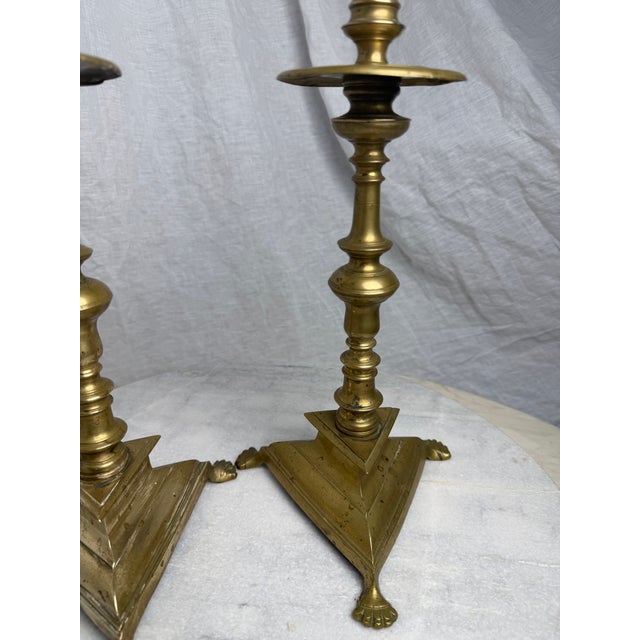 A striking pair of antique, late 19th-century heavy cast brass candlesticks, beautifully modeled in the early Spanish...