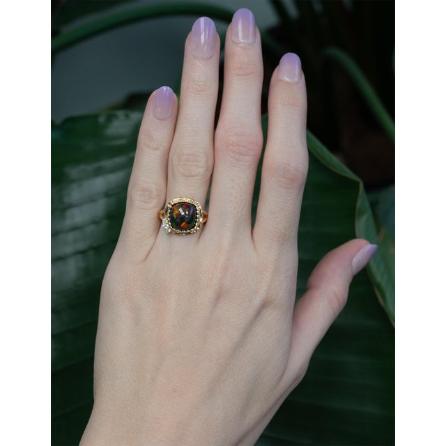A striking 3.9Ct black opal set in solid 14K gold, accented with earth-mined diamonds that enhance its mesmerizing play of...