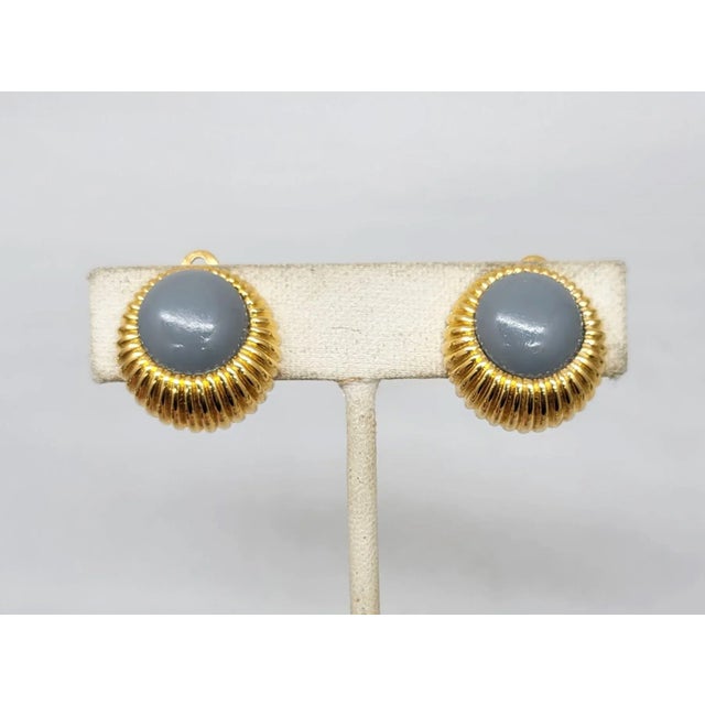 This is part of Chairish’s Costume Jewelry assortment. 1980s round ridged goldtone with cabochon grey resin rhinestone...