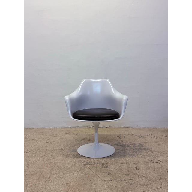 Pair of Tulip Pedestal Collection swivel arm chairs with black Prairie phthalate-free vinyl cushions and white lacquered...