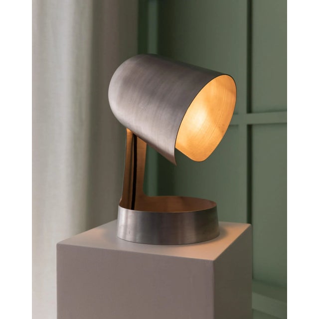 German vintage design at its Best, rotated aluminum shade, 3D cut, open and curved, this table lamp brings warm light to...