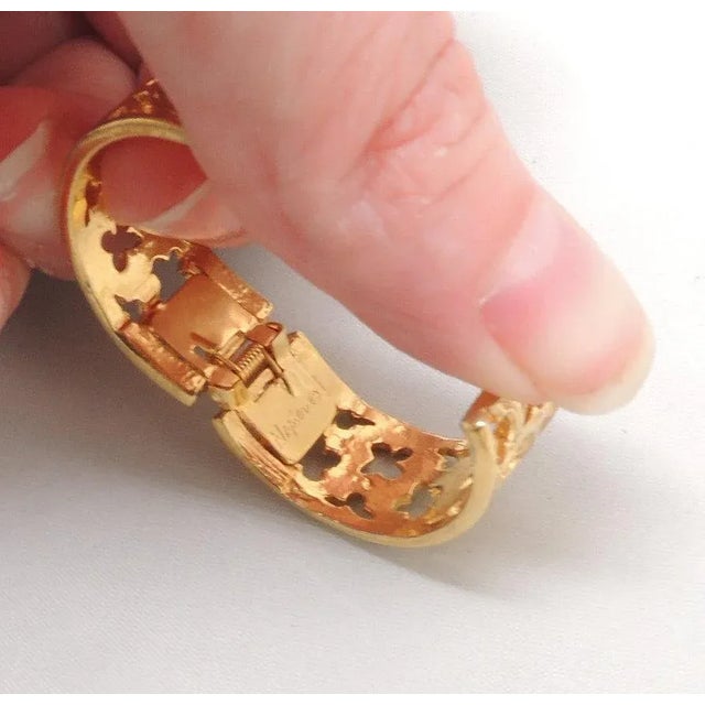 This is part of Chairish’s Costume Jewelry assortment. Goldtone gothic cut out hoop hinged hoop clip backs. Marked...