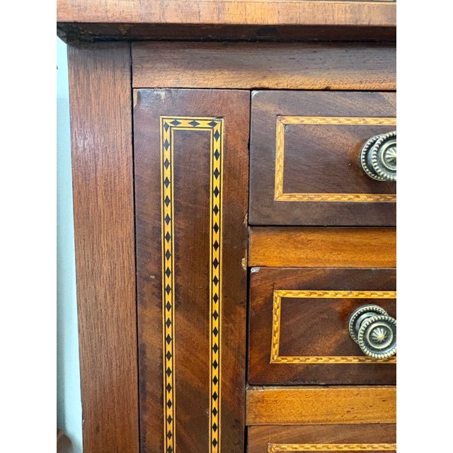 A refined English neoclassical side cabinet or dressing chest, raised on elegant square tapering legs and richly adorned...