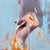 This oil painting captures a delicate hand poised in motion, suggesting a moment of contemplation or creativity. The...