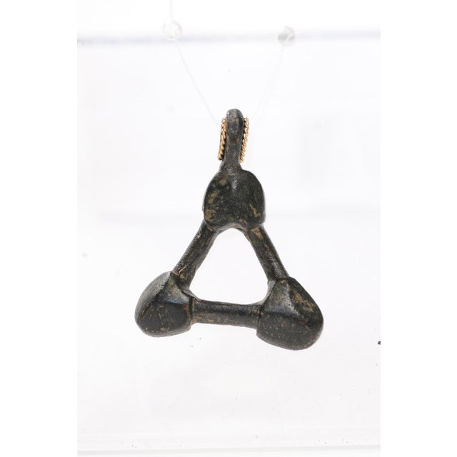 A unique bronze geometric artifact from the Ancient Roman Empire, fashioned into a pendant trimmed with 21 karat gold bail...