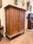 This is a beautiful antique pine armoire cabinet showcasing a classic paneled façade and a rich, naturally aged finish...