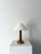 A hand turned wooden table lamp with a simple yet decorative stem, supported on a circular plinth base with squashed bun...