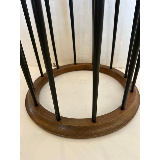 Mid century round glass top side table with elegant ebonized spindles and natural warm wood periphery around the glass and...