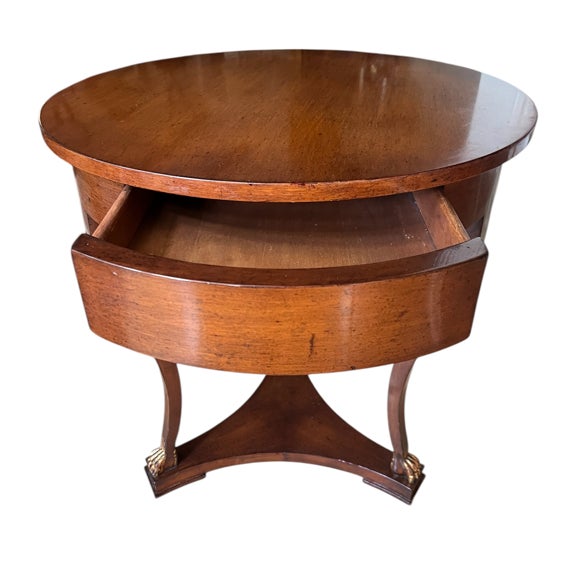 English Regency-style occasional table with a single, curved drawer built into the frieze. Circular top with a deep apron,...